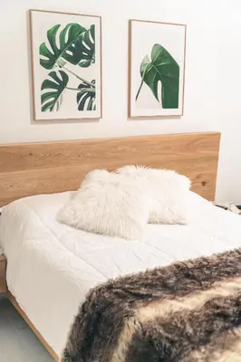 a bed with a white blanket and two pictures on the wall at Apto 203 - Casa bendita in Medellín