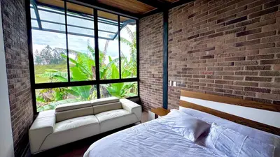 a bedroom with a white bed and a brick wall at Babakan in San Rafael