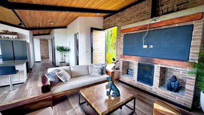 a living room with a couch and a brick fireplace at Babakan in San Rafael