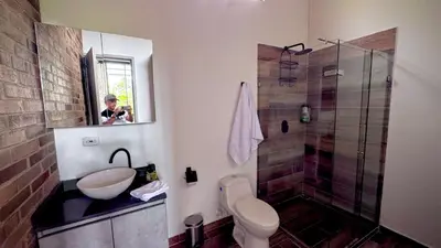 a man taking a picture of a bathroom at Babakan in San Rafael