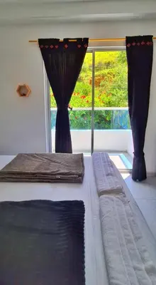 a bedroom with a bed and a large window at OSIMiRI JAMAICA II-Piscina, naturaleza mágica in San Rafael