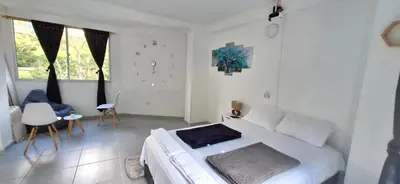a white bedroom with a bed and a table and chairs at OSIMiRI JAMAICA II-Piscina, naturaleza mágica in San Rafael