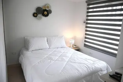 a white bed in a bedroom with a window at Divino Apartamento Moderno con la Mejor Ubicación in Manizales