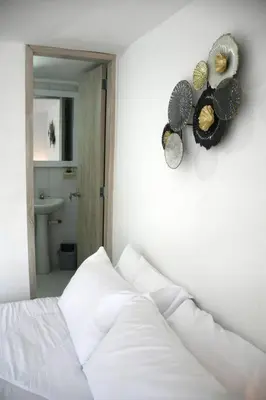 a bedroom with a white bed and a mirror at Divino Apartamento Moderno con la Mejor Ubicación in Manizales