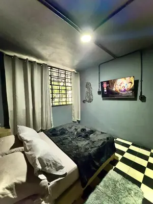a bedroom with a bed and a tv on the wall at Spacious dream house Medellín Laureles in Medellín