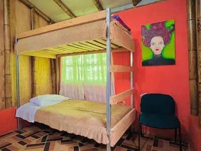 a bedroom with a bunk bed and a chair at Hospedate entre Cascadas, Senderos y Paisajes Naturales in Jardin
