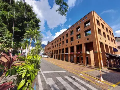 a brick building on a city street with a crosswalk at Loft en el exclusivo barrio Poblado - Medellín in Medellín