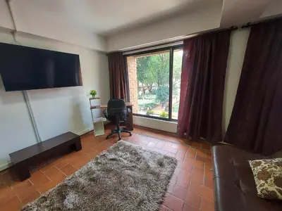 a living room with a couch and a large window at Loft en el exclusivo barrio Poblado - Medellín in Medellín