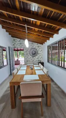 a dining room with a wooden table and chairs at Casa campestre, Guarne-Aeropuerto José María Córdova in Guarne