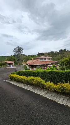 a house on a street with bushes and a road at Casa campestre, Guarne-Aeropuerto José María Córdova in Guarne