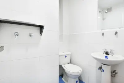 a white bathroom with a toilet and a sink at International House Co-Living in Medellín