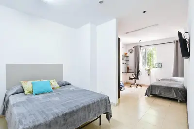 a bedroom with a bed with a blue pillow on it at International House Co-Living in Medellín