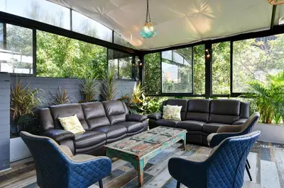 a living room with leather couches and a table and chairs at International House Co-Living in Medellín