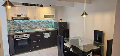 a kitchen with a glass table and a counter top at Hermosa casa con espacios independientes cerca a Mall plaza in Manizales
