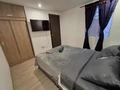 a bedroom with a bed and a television in a room at Hermosa casa con espacios independientes cerca a Mall plaza in Manizales