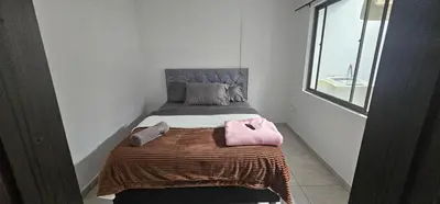 a small bedroom with a bed with a blanket and a window at Hermosa casa con espacios independientes cerca a Mall plaza in Manizales