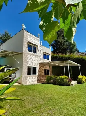 a house with a yard with a car parked in front of it at Acogedora Casa De Campo Con Jakuzzi, Descanso Garantizado in El Peñol