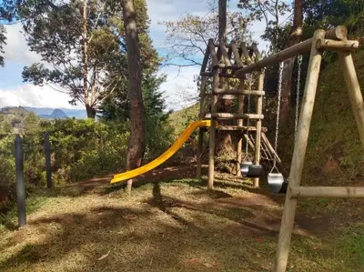 a playground with a yellow slide in a park at Acogedora Casa De Campo Con Jakuzzi, Descanso Garantizado in El Peñol