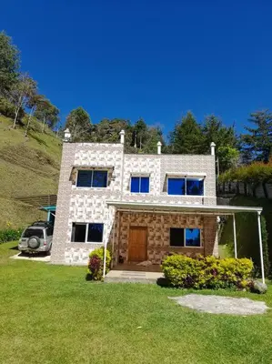 a brick house with a car parked in front of it at Acogedora Casa De Campo Con Jakuzzi, Descanso Garantizado in El Peñol