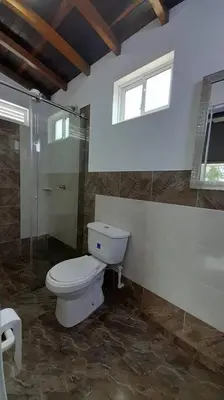 a bathroom with a toilet and a glass shower at Acogedora Casa De Campo Con Jakuzzi, Descanso Garantizado in El Peñol