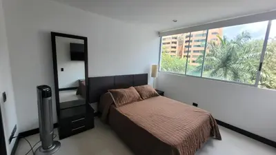 a bedroom with a bed and a large window at Amazing apartment in el Poblado in Medellín