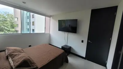 a bedroom with a bed and a flat screen tv at Amazing apartment in el Poblado in Medellín