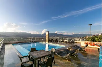 a pool on the roof of a building with a table and chairs at Amazing apartment in el Poblado in Medellín