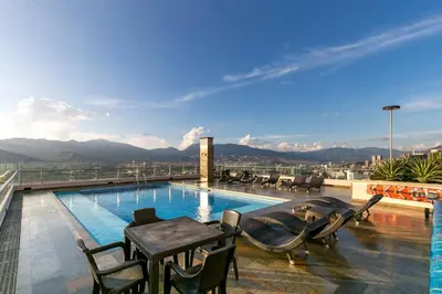 a patio with a table and chairs next to a swimming pool at Amazing apartment in el Poblado in Medellín