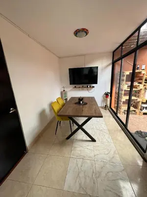 a dining room with a table and yellow chairs at Casa RAPA La70 in Medellín