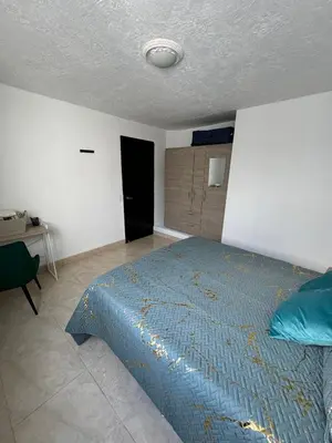 a bedroom with a bed with a blue comforter at Casa RAPA La70 in Medellín