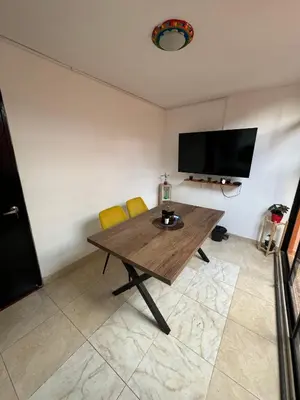 a living room with a wooden table and two yellow chairs at Casa RAPA La70 in Medellín