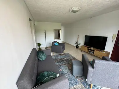 a living room with a couch and a flat screen tv at Casa RAPA La70 in Medellín