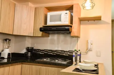 a kitchen with a stove and a microwave at ALOJARTE RIONEGRO - Acogedor estudio - ubicación privilegiada in Rionegro