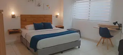 a bedroom with a large bed with blue pillows at ALOJARTE RIONEGRO - Acogedor estudio - ubicación privilegiada in Rionegro