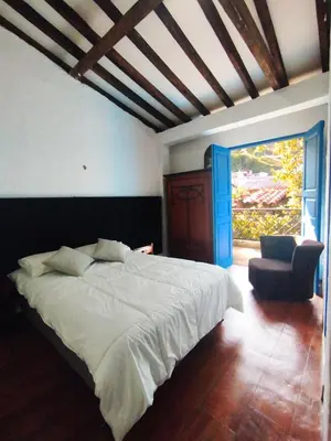 a bedroom with a large white bed and a chair at Patio Chic House in Jericó