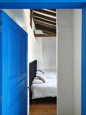 a blue door leading to a bed in a room at Patio Chic House in Jericó