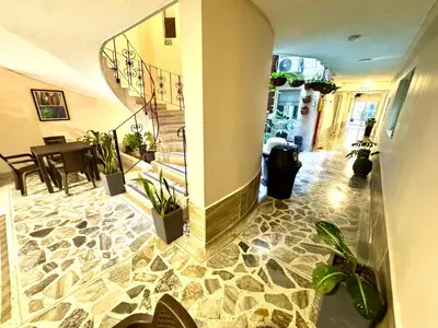 a hallway with potted plants and stairs in a building at Hotel Estadio 80 in Medellín