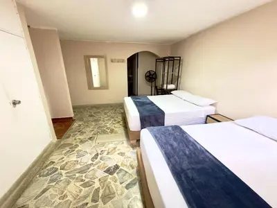 a hotel room with two beds and a stone floor at Hotel Estadio 80 in Medellín