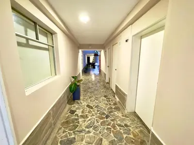 a hallway with a tile floor and a window at Hotel Estadio 80 in Medellín