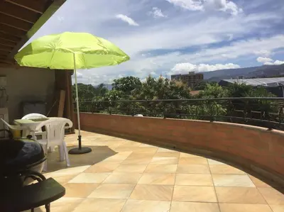 a patio with a green umbrella and a table and chair at Vista Magnolia in Envigado