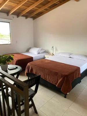 a bedroom with two beds and a table with a chair at Hermoso Aparta-Estudio En Envigado cerca de Medellin in Envigado