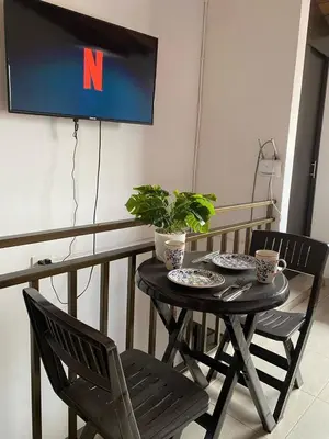a table with two chairs and a tv on a wall at Hermoso Aparta-Estudio En Envigado cerca de Medellin in Envigado