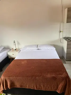 a bedroom with a bed with a brown blanket on it at Hermoso Aparta-Estudio En Envigado cerca de Medellin in Envigado