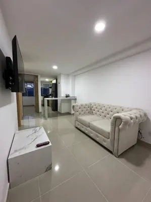 a living room with a couch and a tv at Medellín central in Medellín