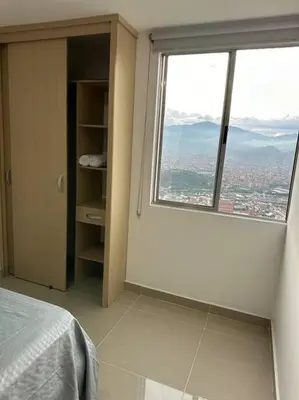 a bedroom with a large window with a view of a city at Medellín central in Medellín