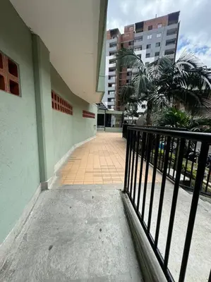 a balcony of a building with a fence and palm trees at Medellín central in Medellín