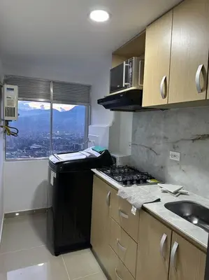 a kitchen with a stove and a sink and a window at Medellín central in Medellín