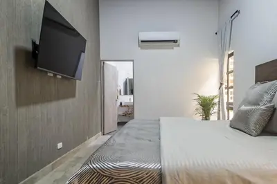 a bedroom with a bed with a flat screen tv on the wall at Monteclaro Campestre - En Sopetran in Sopetran