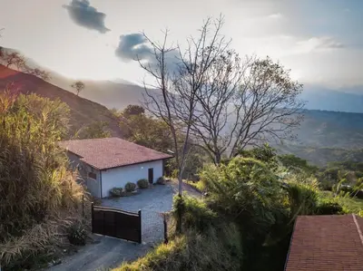 a small white house in the middle of a mountain at Monteclaro Campestre - En Sopetran in Sopetran
