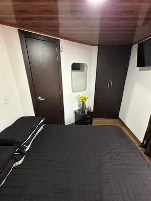 a bedroom with a bed and two black doors at Habitación privada in Manizales